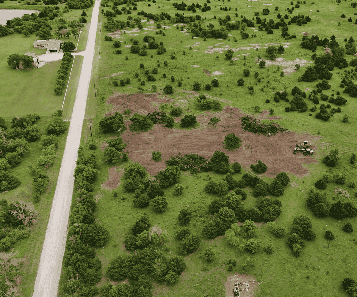 Aerial view of a rural Oklahoma property showing stages of land clearing, vegetation removal, and grading by heavy equipment.