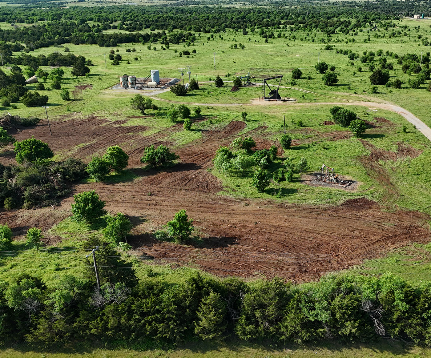 Aerial view of large Oklahoma pasture after machine clearing, with rows of bare earth.
